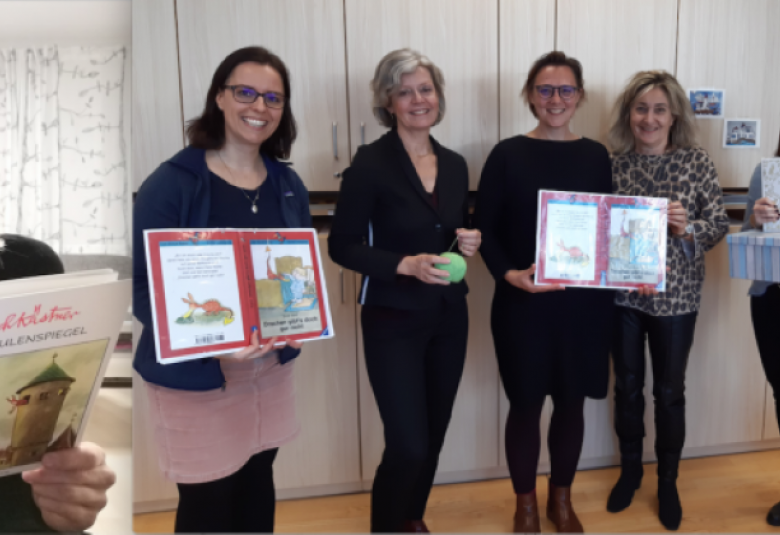 Sie sehen das Team der Pädagogischen Hochschule Tirol am Tiroler Vorlesetag. Es werden lächelnd Bücher gezeigt.