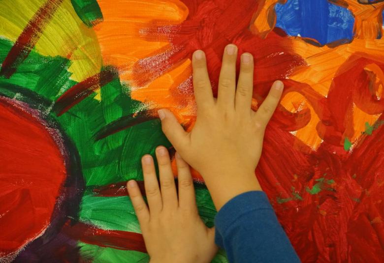 Symbolbild Elementarpädagogik - Kinderhände auf buntem Bild