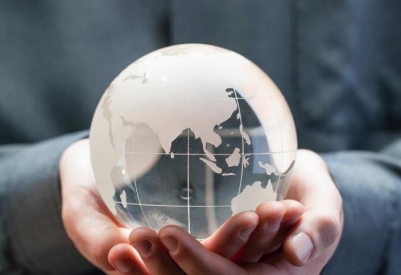 Symbolbild für Nachhaltigkeit: eine Person hält einen gläsernen Globus in der Hand.