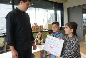 Zwei Schüler:innen übergeben die Spende an das Jugendland