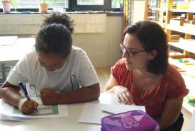 Sabrina Gerth begleitet ein Kind beim Schreibprozess.