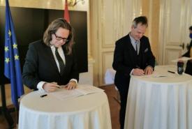 Bundesminister Martin Polaschek und Rektor Thomas Schöpf unterzeichnen und präsentieren den ZLP