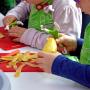 Kindergartenkinder beim Kartoffelschälen im Kochkurs